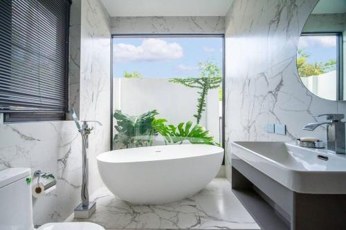 苏梅岛KOTE Private Pool Villa的浴室配有大型白色浴缸和水槽