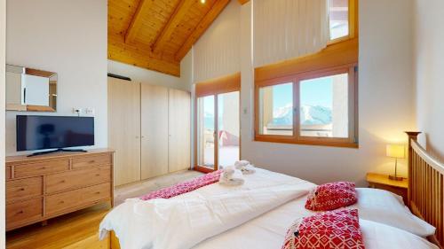 韦松纳Ski Heaven LUXE & CENTER apartments的一间卧室设有一张大床、电视和窗户。