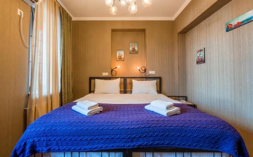 第比利斯格米街19号酒店的一间卧室配有蓝色的床和毛巾