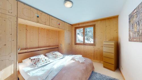 韦松纳Balcons du Soleil QUIET & SUNNY apartments by Alpvision Résidences的卧室配有木墙内的一张床