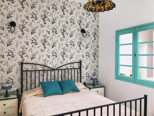 丰卡连特德拉帕尔马Casa Las Enanitas I - Casa Leo的一间卧室配有一张带花卉壁纸的床
