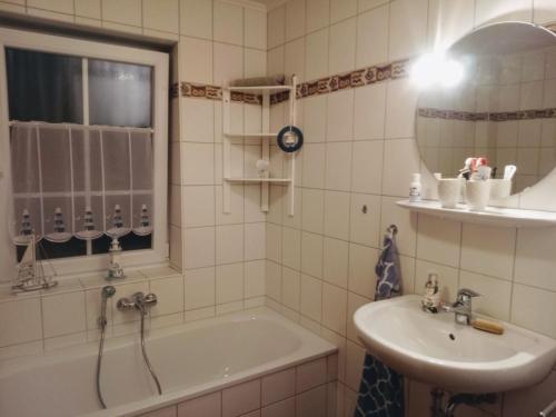 奈斯玛兹埃勒Drei-Insel-Blick Neßmersiel的带浴缸、水槽和镜子的浴室