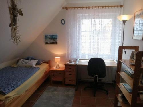 奈斯玛兹埃勒Drei-Insel-Blick Neßmersiel的一间卧室配有一张床、一张书桌和一个窗户。