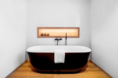 达沃斯ALPINE INN Davos的带浴缸的浴室和白色墙壁