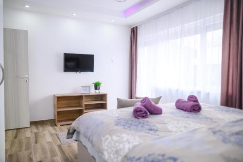 索科矿泉村Sara Lux的一间卧室配有一张带紫色枕头的床