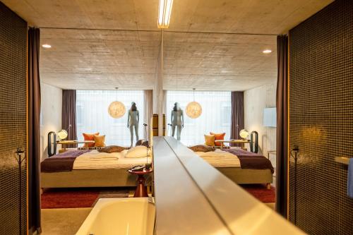 巴塞尔游牧设计与生活方式酒店的一间带两张床和镜子的浴室