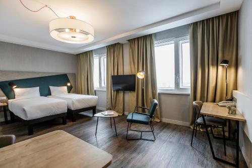 基辅Adagio Kyiv Beresteiska的酒店客房配有一张床铺和一张桌子。