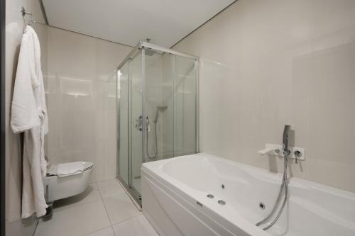 代胡克DDK Hotel Duhok的带淋浴和浴缸的白色浴室