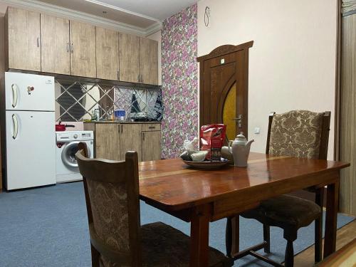 撒马尔罕Hostel Highway的厨房配有木桌和白色冰箱。