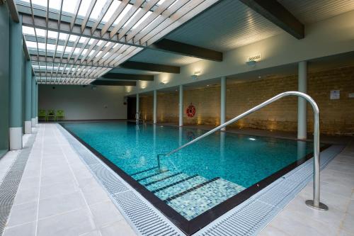 埃文河畔布拉德福伍利农庄奢华家庭旅馆的大楼内一个蓝色的大型游泳池
