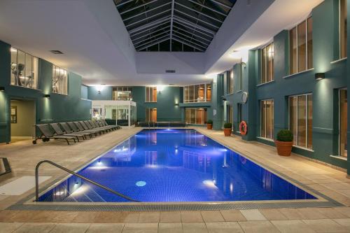 萨顿·斯科特尼Norton Park Hotel, Spa & Manor House - Winchester的一座带游泳池的大楼内的大型游泳池