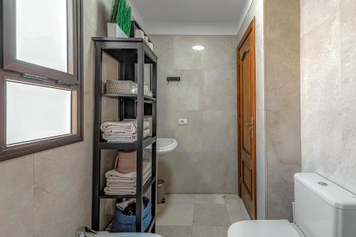 卡亚俄萨尔瓦赫Casa del Mar的一间带卫生间的浴室和一个带毛巾的架子