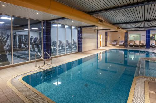 凯尼尔沃思Chesford Grange Hotel的一座带健身房的大楼内的大型游泳池