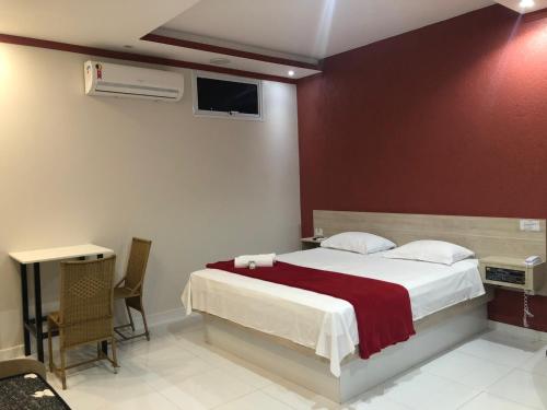 圣代佩德罗HOTEL E POUSADA ISIS的一间卧室设有一张红色墙壁的大床