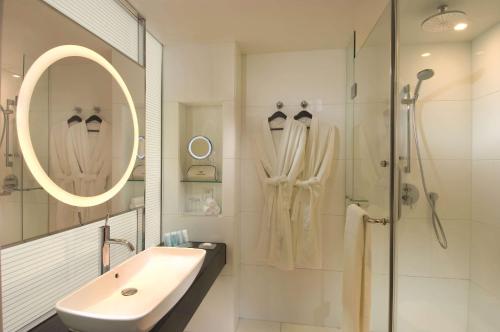 北京北京希尔顿逸林酒店的白色的浴室设有水槽和淋浴。