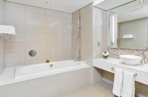 卢萨卡Hilton Garden Inn Society Business Park的白色的浴室设有浴缸和水槽。