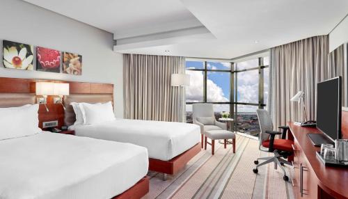 卢萨卡Hilton Garden Inn Society Business Park的酒店客房配有两张床和一张书桌