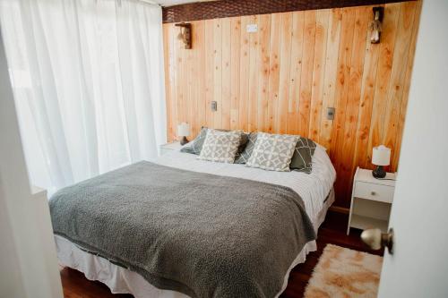 比亚里卡Leftraro Lodge Urbano的一间卧室配有一张带木墙的大床