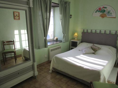 Tourville-sur-SienneLe haut Manoir的一间卧室设有一张床、一个窗口和一面镜子