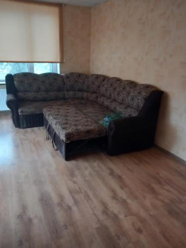 巴尔维Balvu centrs Partizanu 10的客厅设有一张沙发,铺有木地板
