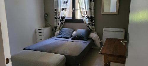 巴邦塔纳Les Cigales的一间小卧室,配有两张床和一张桌子