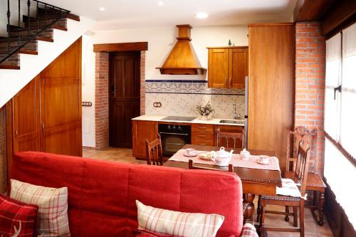 卢安科Casa Rural La Tayuela的客厅设有红色沙发,位于厨房内