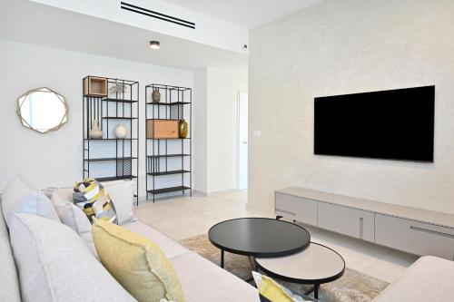 特拉维夫Summer White by HolyGuest的客厅配有沙发和墙上的电视