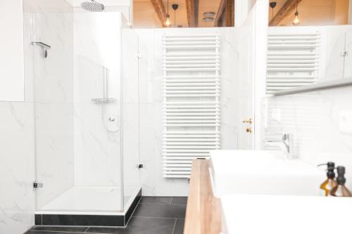 拉芬斯堡HEIMATEL - Luxury Penthouse Loft的带淋浴和盥洗盆的白色浴室
