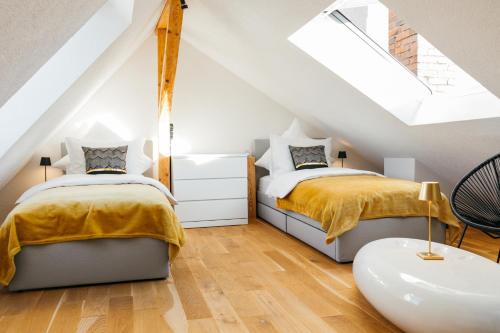 拉芬斯堡HEIMATEL - Luxury Penthouse Loft的阁楼卧室设有两张床和天窗