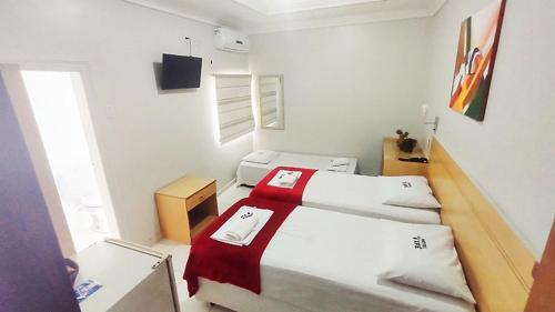 贝伦艺佩酒店的一间白色的小房间,里面设有两张床