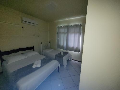 塞尔苏拉穆斯州长镇Casa Master com Piscina em Gov Celso Ramos的酒店客房设有两张床和窗户。