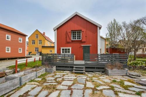 莫舍恩Sjøgata Riverside Rental and Salmon Fishing的前面有长凳的红色建筑