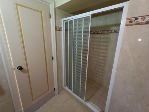 比雷埃夫斯昆斯勒瑞欧蒂斯酒店的浴室里设有玻璃门淋浴