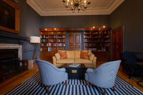 福伊Fowey Hall Hotel的客厅配有沙发、椅子和壁炉
