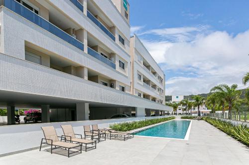 弗洛里亚诺波利斯Cannes Club Residence a 200m da praia, recém inaugurado的酒店庭院设有椅子和游泳池