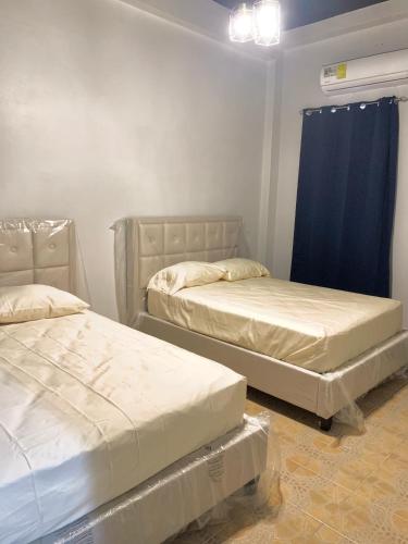 巴拿马城Centrico Apartamento Barrio de La Exposición的配有蓝色窗帘的客房内的两张床