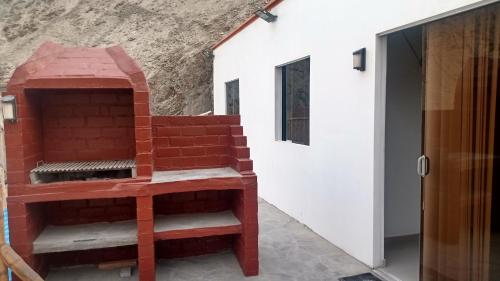 谢内吉亚区Casa en cineguilla的砖炉,坐在建筑物旁边