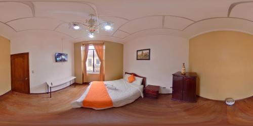昆卡4莫多斯酒店的一间卧室配有一张带橙色毯子的床