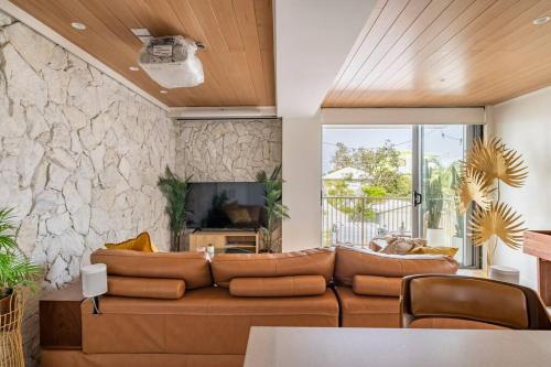黄金海岸Chic beachside getaway 2BR 2Bath Fully Equipped的客厅设有棕色的沙发和石墙