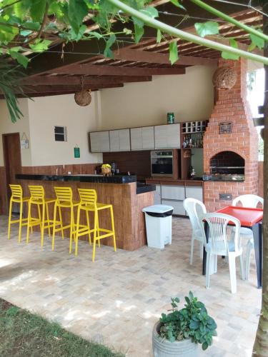 彼得罗利纳Chácara aconchego do Valle的庭院设有带黄色椅子的酒吧和厨房
