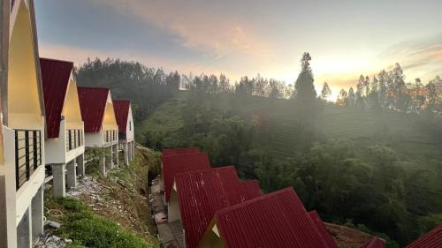 岩望Hotel Nature Bromo and Resort的山丘上的一排房子,背景是日落