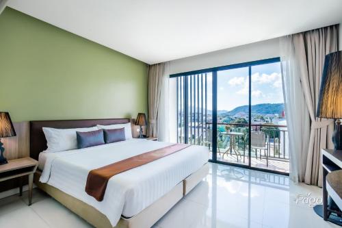 普吉镇The Pago Design Hotel Phuket-SHA Plus的一间卧室设有一张大床和一个大窗户