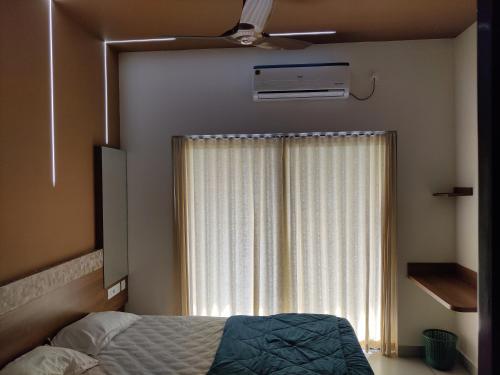 奎隆Eva Meadows的一间卧室配有一张床和一个带风扇的窗户。