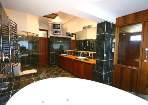 Dural瑞莱克辛住宿加早餐旅馆的大型浴室设有两个盥洗盆和大镜子