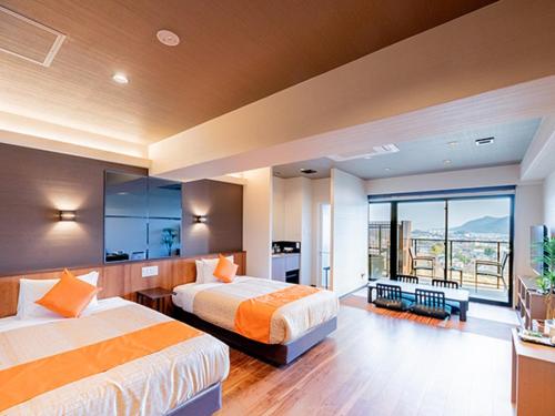 廿日市LiVEMAX RESORT Miyahama Ocean View的酒店客房设有两张床和一个阳台。
