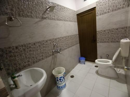 坎普尔Chhabra Guest House, Kanpur的一间带卫生间、水槽和小便室的浴室