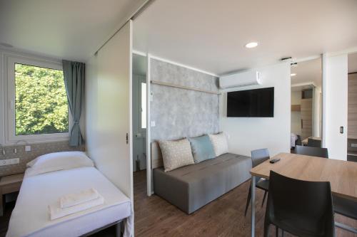 希贝尼克Deluxe Beach Mobile Homes的酒店客房配有一张床铺和一张桌子。