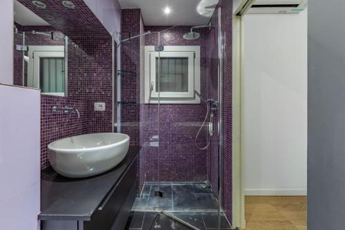 米兰Turro Cozy Apartment的一间带水槽和玻璃淋浴的浴室