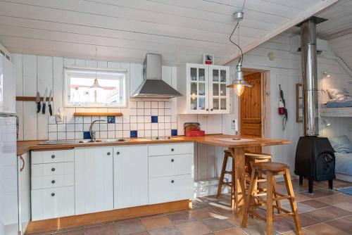 胡迪克斯瓦尔Seaside Cottage Nr 3, Saltvik Hudiksvall的厨房配有白色橱柜和木制台面