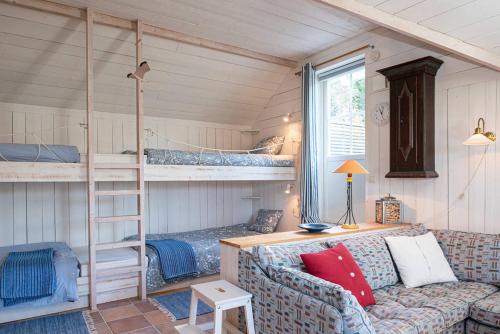 胡迪克斯瓦尔Seaside Cottage Nr 3, Saltvik Hudiksvall的带沙发和双层床的客厅